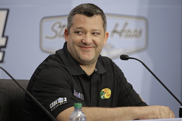 Three-time NASCAR champion Tony Stewart smiles as he announces he will retire after the 2016 season during a news conference at Stewart-Haas Racing's headquarters in Kannapolis, N.C., Wednesday, Sept. 30, 2015. (AP Photo/Chuck Burton)