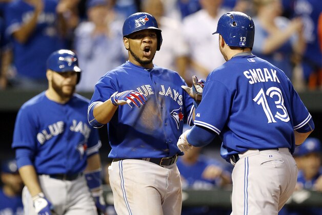 Toronto Blue Jays' Edwin Encarnacion, center, celebrates with teammate Justin Smoak after Smoak batted him in on a home run in the ninth inning in the first baseball game of a doubleheader against the Baltimore Orioles, Wednesday, Sept. 30, 2015, in Baltimore. Toronto won 15-2 to clinch the American League East. (AP Photo/Patrick Semansky)