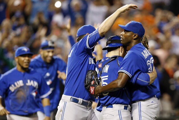 Toronto Blue Jays relief pitcher LaTroy Hawkins, right, celebrates with catcher Russell Martin, second from left, and teammate Chris Colabello after closing out the first baseball game of a doubleheader against the Baltimore Orioles, Wednesday, Sept. 30, 2015, in Baltimore. Toronto won 15-2 to clinch the American League East. (AP Photo/Patrick Semansky)