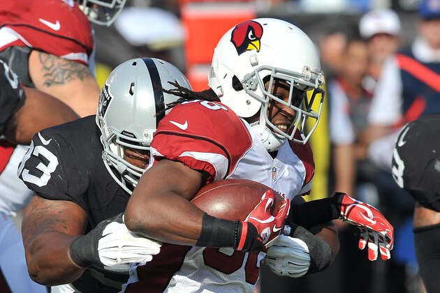 Arizona Cardinals running back (38) Andre Ellington tries to get away from Oakland Raiders defensive tackle (93) Rickey Lumpkin during a preseason game played at O.co Coliseum in Oakland on Sunday, Aug. 30, 2015. (AP Photo/John Cordes)