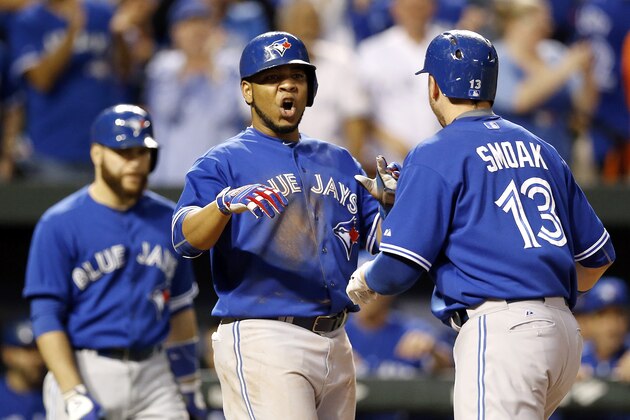 Toronto Blue Jays' Edwin Encarnacion, center, celebrates with teammate Justin Smoak after Smoak batted him in on a home run in the ninth inning in the first baseball game of a doubleheader against the Baltimore Orioles, Wednesday, Sept. 30, 2015, in Baltimore. Toronto won 15-2 to clinch the American League East. (AP Photo/Patrick Semansky)