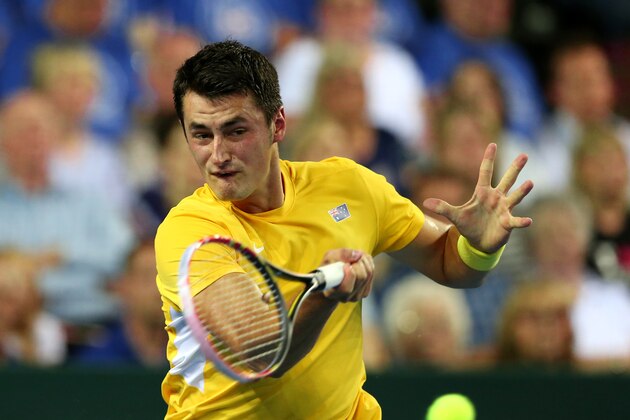 Australia's Bernard Tomic plays a return to Britain's Andy Murray during a semifinal tennis match of the Davis Cup between Britain and Australia in Glasgow, Scotland, Sunday Sept. 20, 2015. (AP Photo/Scott Heppell)