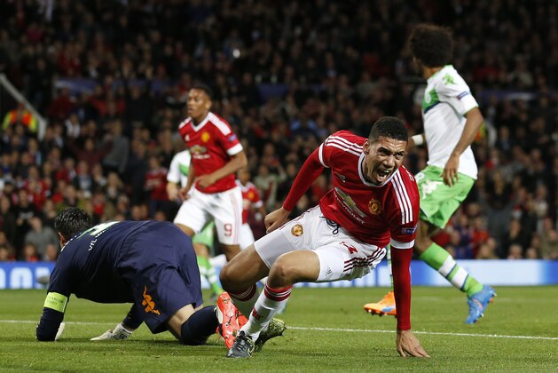Manchester United's Chris Smalling, center right, celebrates after scoring during the Champions League Group B soccer match between Manchester United and VfL Wolfsburg at Old Trafford Stadium in Manchester, England, Wednesday, Sept. 30, 2015. (AP Photo/Jon Super)