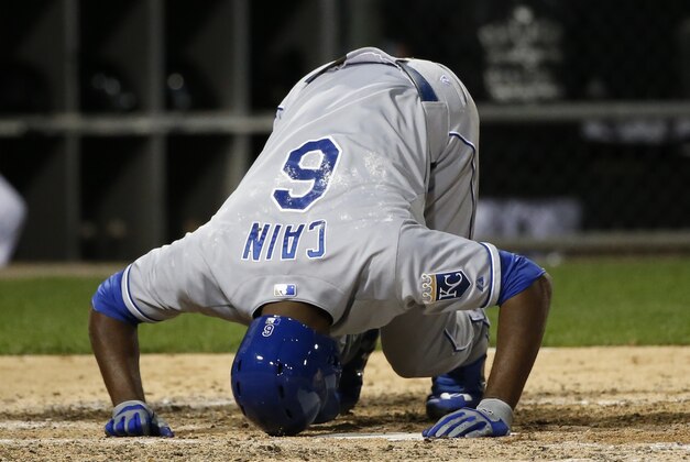 Kansas City Royals' Lorenzo Cain kneels on the ground after fouling a pitch from Chicago White Sox starting pitcher Jose Quintana during the seventh inning of a baseball game Wednesday, Sept. 30, 2015, in Chicago. (AP Photo/Charles Rex Arbogast)