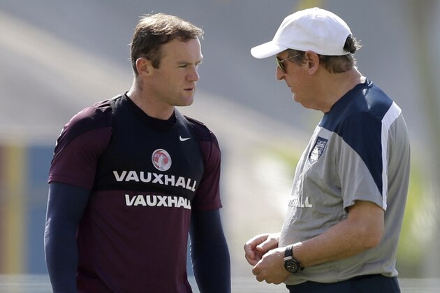FILE - This is a Monday, June 16, 2014 file photo of England national soccer team coach Roy Hodgson, right, as he speaks with Wayne Rooney during a squad training session for the 2014 soccer World Cup at the Urca military base in Rio de Janeiro, Brazil. Wayne Rooney was named England captain on Thursday, Aug. 28, 2014 taking over the leadership role of an inexperienced team in a rebuilding phase following its worst-ever World Cup. (AP Photo/Matt Dunham, File) FILE - This is a Monday, June 16, 2014 file photo of England national soccer team coach Roy Hodgson, right, as he speaks with Wayne Rooney during a squad training session for the 2014 soccer World Cup at the Urca military base in Rio de Janeiro, Brazil. Wayne Rooney was named England captain on Thursday, Aug. 28, 2014 taking over the leadership role of an inexperienced team in a rebuilding phase following its worst-ever World Cup. (AP Photo/Matt Dunham, File)