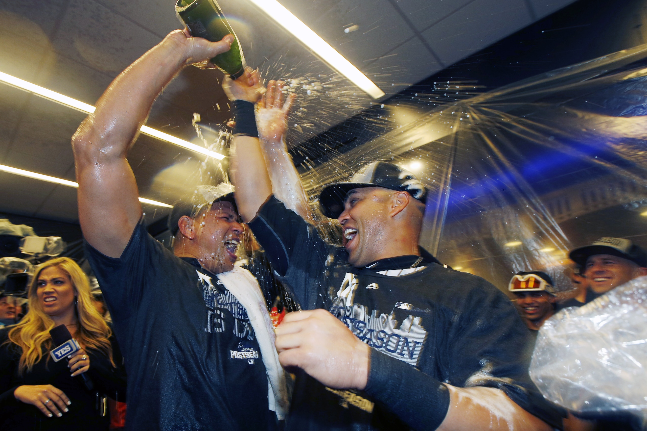 New York Yankees designated hitter Alex Rodriguez, left, celebrates with New York Yankees right fielder Carlos Beltran in the locker room after the Yankees clinched a wild car berth in the playoffs after defeating the Boston Red Sox 4-1 in a baseball game in New York, Thursday, Oct. 1, 2015.   (AP Photo/Kathy Willens)