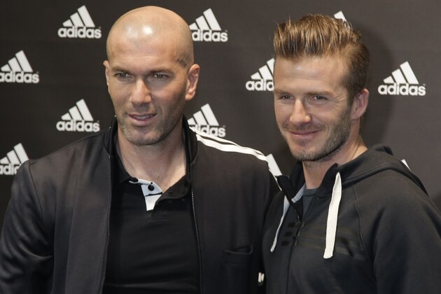Soccer legend Zinedine Zidane, left, and Paris Saint Germain's David Beckham pose for a photograph, during a media event, in a sports store, on the Champs Elysees Avenue, in Paris, Thursday, Feb. 28, 2013. (AP Photo/Francois Mori)