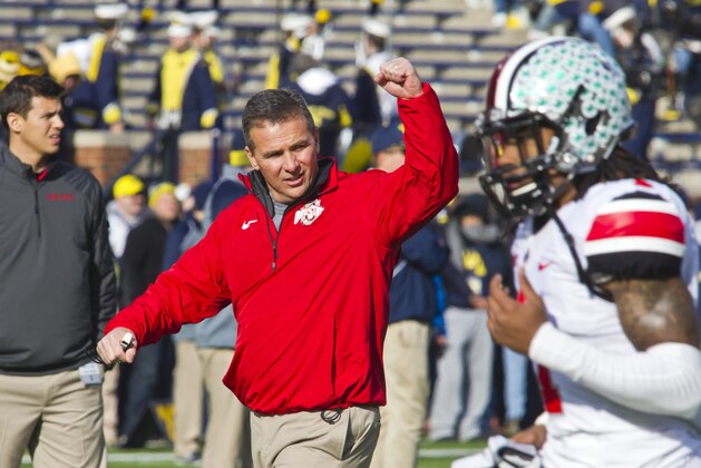 Ohio State head coach Urban Meyer responds to cheers for him from fans in Michigan Stadium as his team takes the field before an NCAA college football game against Michigan in Ann Arbor, Mich., Saturday, Nov. 30, 2013. (AP Photo/Tony Ding)