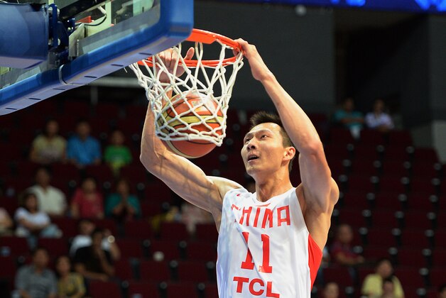 China's Yi Jianlian (top) dunks the ball against Jordan during their men's Asia Championships basketball game in Manila on August 10, 2013. China won 79-76.   AFP PHOTO / TED ALJIBE        (Photo credit should read TED ALJIBE/AFP/Getty Images)