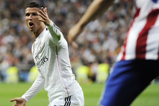 Real Madrid's portuguese forward Cristiano Ronaldo complains as he kneels on the ground during the UEFA Champions League quarter-finals second leg football match Real Madrid CF vs Club Atletico de Madrid at the Santiago Bernabeu stadium in Madrid on April 22, 2015.      AFP PHOTO / CURTO DE LA TORRE        (Photo credit should read CURTO DE LA TORRE/AFP/Getty Images)