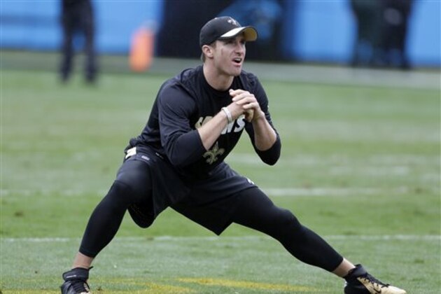 FILE - In this Sept. 27, 2015, file photo, New Orleans Saints' Drew Brees stretches before an NFL football game against the Carolina Panthers in Charlotte, N.C. Brees is trying to work his way back into the lineup after missing last week's game with a throwing shoulder injury.  (AP Photo/Bob Leverone, File)