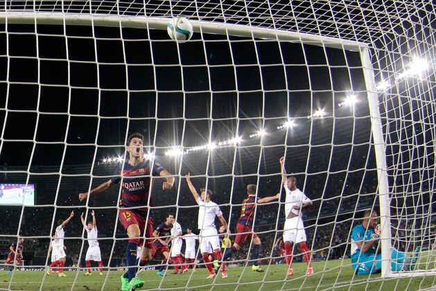 Barcelona's Marc Bartra, center left, watches the ball hit the net after teammate Pedro Rodriguez scored the winning goal during the UEFA Super Cup soccer match between FC Barcelona and Sevilla FC at the Boris Paichadze Dinamo Arena stadium, in Tbilisi, Georgia, on Wednesday, Aug. 12, 2015. Barcelona won 5-0. (AP Photo/Ivan Sekretarev)