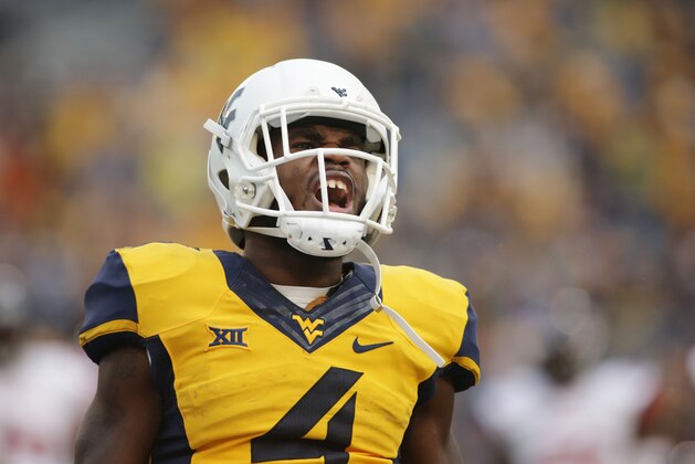 West Virginia running back Wendell Smallwood (4) celebrates after running for a touchdown during the second half of a NCAA college football game against Liberty, Saturday, Sept. 12, 2015, in Morgantown, W.Va. West Virginia defeated Liberty 41-17. (AP Photo/Raymond Thompson)