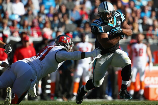 CHARLOTTE, NC - DECEMBER 14:    Jonathan Stewart #28 of the Carolina Panthers runs from  Da'Quan Bowers #91 of the Tampa Bay Buccaneers in the 1st quarter during their game at Bank of America Stadium on December 14, 2014 in Charlotte, North Carolina.  (Photo by Streeter Lecka/Getty Images)