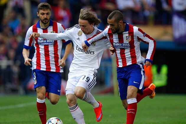 MADRID, SPAIN - APRIL 14: Luka Modric of Real Madrid CF is closed down by Guilherme Siqueira and Mario Suarez of Atletico Madrid (R) during the UEFA Champions League Quarter Final First Leg match between Club Atletico de Madrid and Real Madrid CF at Vicente Calderon Stadium on April 14, 2015 in Madrid, Spain.  (Photo by Gonzalo Arroyo Moreno/Getty Images)