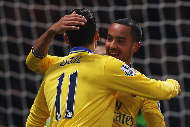 LONDON, ENGLAND - DECEMBER 26:  Theo Walcott of Arsenal (R) celebrates with Mesut Oezil (11) as he scores their first goal during the Barclays Premier League match between West Ham United and Arsenal at Boleyn Ground on December 26, 2013 in London, England.  (Photo by Ian Walton/Getty Images)