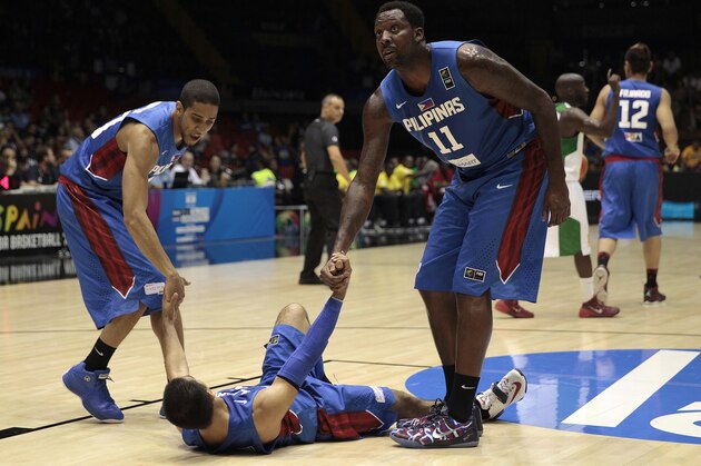 Philippines players Andray Blatche, right, and Gabe Norwood, left, help teammate Lewis Tenorio during the Group B Basketball World Cup match against Senegal in Seville, Spain, Thursday, Sept. 4, 2014. The 2014 Basketball World Cup competition will take place in various cities in Spain from Aug. 30 through to Sept. 14. (AP Photo/Miguel Angel Morenatti)
