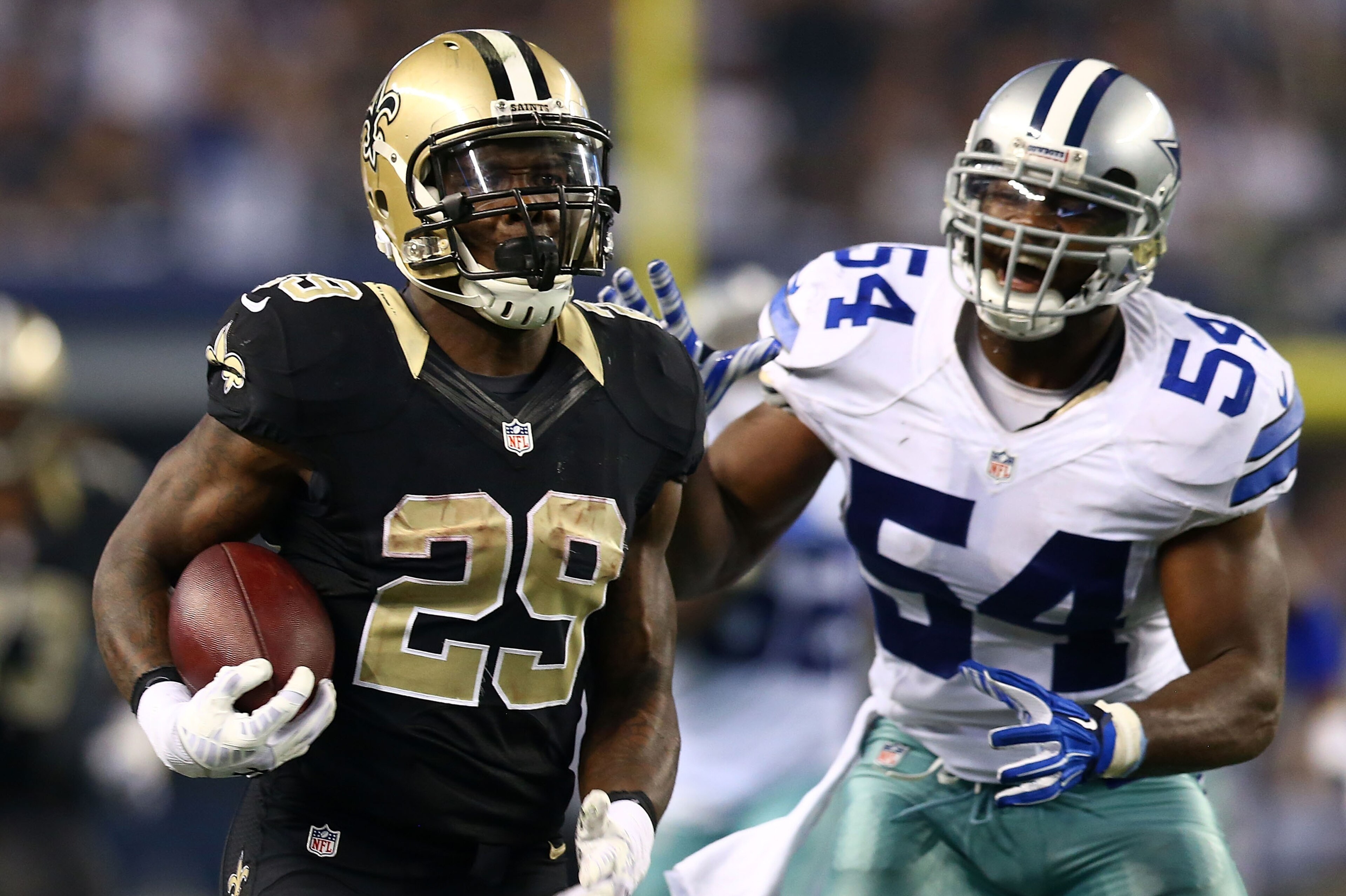 ARLINGTON, TX - SEPTEMBER 28:  Khiry Robinson #29 of the New Orleans Saints runs with the ball as Bruce Carter #54 of the Dallas Cowboys pursues in the second half at AT&T Stadium on September 28, 2014 in Arlington, Texas.  (Photo by Ronald Martinez/Getty Images)