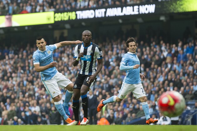 Manchester City's Sergio Aguero, left, scores past Newcastle's Chancel Mbemba for his third of five goals as David Silva looks on during the English Premier League soccer match between Manchester City and Newcastle at the Etihad Stadium, Manchester, England, Saturday Oct. 3, 2015. (AP Photo/Jon Super)