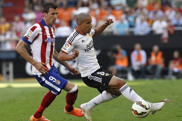 Atletico's Mario Mandzukic, left,  duels for the ball with Valencia's  Sofiane Feghouli during a Spanish La Liga soccer match at the Mestalla stadium in Valencia, Spain, on Saturday, Oct. 4, 2014.(AP Photo/Alberto Saiz)