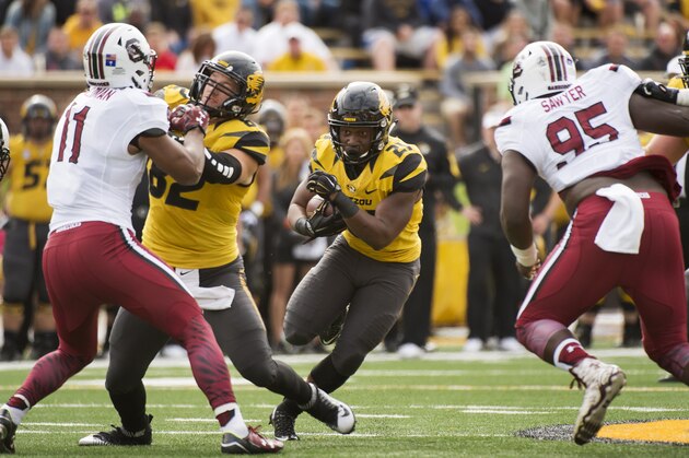 Missouri running back Ish Witter, center, runs between South Carolina's Dante Sawyer, right, and T.J. Holloman, left, behind the block of Clayton Echard during the first quarter of an NCAA college football game Saturday, Oct. 3, 2015, in Columbia, Mo. (AP Photo/L.G. Patterson)