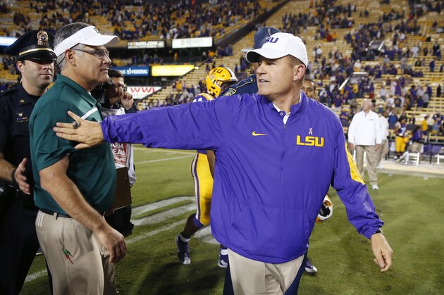 LSU head coach Les Miles, right, greets Eastern Michigan head coach Chris Creighton after an NCAA college football game in Baton Rouge, La., Saturday, Oct. 3, 2015. LSU won 44-22. (AP Photo/Gerald Herbert)