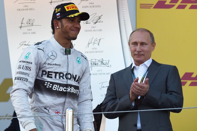 Mercedes' British driver Lewis Hamilton walks to the podium by Russian President Vladimir Putin after winning the inaugural Russian Formula 1 Grand Prix at the Sochi Autodrom in Sochi on October 12, 2014.     AFP PHOTO / DIMITAR DILKOFF        (Photo credit should read DIMITAR DILKOFF/AFP/Getty Images)