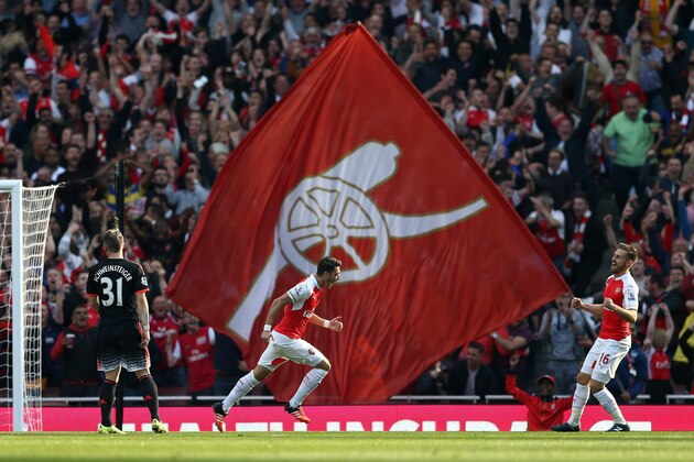 Arsenal's German midfielder Mesut Ozil (C) celebrates with team mate Arsenal's Welsh midfielder Aaron Ramsey after scoring during the English Premier League football match between Arsenal and Manchester United at the Emirates Stadium in London on October 4, 2015.    AFP PHOTO / JUSTIN TALLIS

RESTRICTED TO EDITORIAL USE. No use with unauthorised audio, video, data, fixture lists, club/league logos or 'live' services. Online in-match use limited to 45 images, no video emulation. No use in betting, games or single club/league/player publications.        (Photo credit should read JUSTIN TALLIS/AFP/Getty Images)