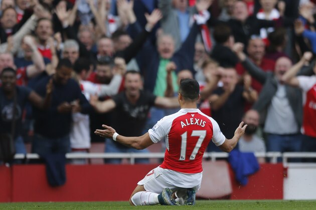 Arsenal's Alexis Sanchez goes onto his knees in front of the crowd as he celebrates scoring his second goal of the game during the English Premier League soccer match between Arsenal and Manchester United at Emirates stadium in London, Sunday, Oct. 4, 2015.(AP Photo/Frank Augstein)