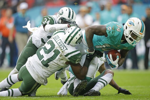 Miami Dolphins' Jarvis Landry, right, is tackled by New York Jets' Marcus Gilchrist during the NFL football game between the New York Jets and the Miami Dolphins and at Wembley stadium in London, Sunday, Oct. 4, 2015. (AP Photo/Matt Dunham)