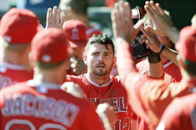 Los Angeles Angels' Johnny Giavotella is congratulated in the dugout by teammates during the ninth inning of a baseball game against the Texas Rangers in Arlington, Texas, Saturday, Oct. 3, 2015. Giovatella hit an RBI single scoring Drew Stubbs in the night inning, leading the Angels to an 11-10 win. (AP Photo/LM Otero)