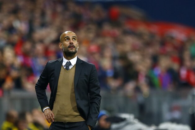 Bayern's head coach Pep Guardiola watches the stadium score board during the German Bundesliga soccer match between FC Bayern Munich and Borussia Dortmund at the Allianz Arena stadium in Munich, Germany, Sunday, Oct. 4, 2015. (AP Photo/Matthias Schrader)