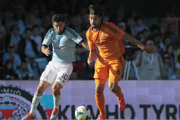 Real Madrid's Sami Khedira, right, vies for the ball with Celta's Manuel Agudo “Nolito”, during a Spanish La Liga soccer match at the Balaidos stadium in Vigo, Spain, Sunday, May 11, 2014. (AP Photo/Lalo R. Villar)