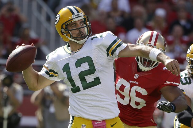 El quarterback Aaron Rodgers (12), de los Packers de Green Bay, lanza un pase antes de la llegada del linebacker Corey Lemonier (96), de los 49ers de San Francisco en la primera mitad del juego en Santa Clara, California, el domingo 4 de octubre de 2015. (AP Photo/Marcio Jose Sanchez)