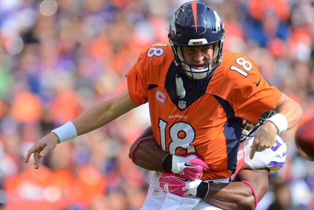 Oct 4, 2015; Denver, CO, USA; Denver Broncos quarterback Peyton Manning (18) is hit by Minnesota Vikings defensive end Everson Griffen (97) as he passes in the first quarter at Sports Authority Field at Mile High. Mandatory Credit: Ron Chenoy-USA TODAY Sports