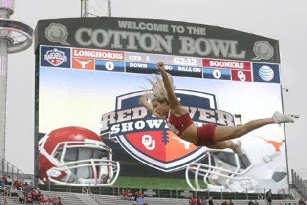 An Oklahoma  cheerleader flies in the air before an NCAA college football game between Texas and Oklahoma at the Cotton Bowl, Saturday, Oct. 11, 2014, in Dallas. (AP Photo/LM Otero)