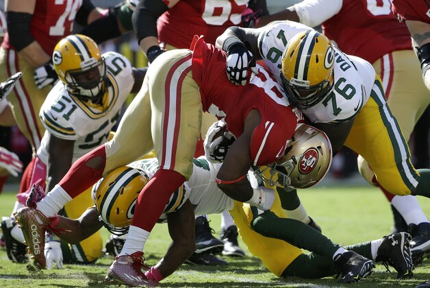 Green Bay Packers defensive end Mike Daniels (76) tackles San Francisco 49ers running back Carlos Hyde (28) during the second half of an NFL football game in Santa Clara, Calif., Sunday, Oct. 4, 2015. (AP Photo/Marcio Jose Sanchez)