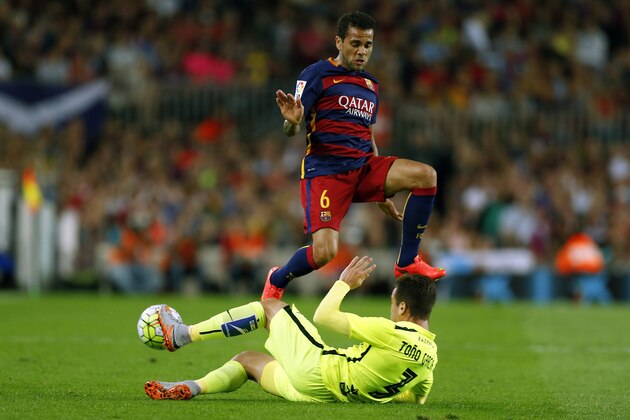 FC Barcelona's Dani Alvez, top, duels for the ball against Levante's Tono Garcia during a Spanish La Liga soccer match at the Camp Nou stadium in Barcelona, Spain, Sunday, Sept. 20, 2015. (AP Photo/Manu Fernandez)