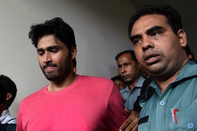 Bangladeshi security personnel escort fugitive cricketer Shahadat Hossain (C) after he surrendered in Dhaka on October 5, 2015. Hossain was remanded in jail on October 5 shortly after he surrendered to a court over allegations of beating his 11-year-old maid, his lawyer said. AFP PHOTO / MUNIR UZ ZAMAN        (Photo credit should read MUNIR UZ ZAMAN/AFP/Getty Images)