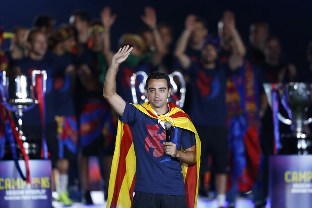 Barcelona's Xavi Hernandez waves to the fans during celebrations at the Camp Nou stadium in Barcelona, Spain Sunday June 7, 2015 after winning the Champions League final soccer match Saturday by beating Juventus Turin 3-1. Barcelona won the triple this season winning the Spanish League title, the Copa del Rey and the Champions League. (AP Photo/Manu Fernandez)