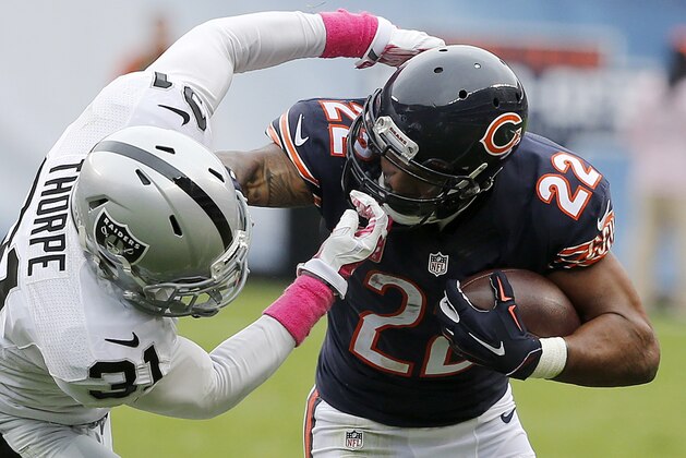 Oakland Raiders cornerback Neiko Thorpe (31) grabs the face mask as he tries to stop Chicago Bears running back Matt Forte (22) during the first half of an NFL football game, Sunday, Oct. 4, 2015, in Chicago. (AP Photo/Charles Rex Arbogast)