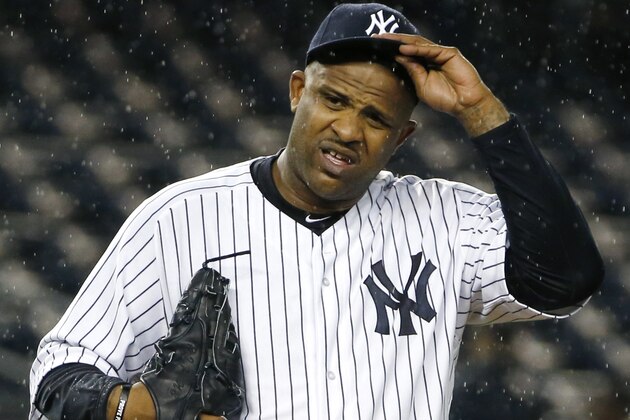 New York Yankees starting pitcher CC Sabathia (52) struggles with his cap in the rain during the first inning of a baseball game against the Boston Red Sox in New York, Thursday, Oct. 1, 2015.   (AP Photo/Kathy Willens)