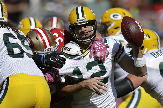 Green Bay Packers quarterback Aaron Rodgers (12) is pressured by San Francisco 49ers linebacker Aaron Lynch (59) during the first half of an NFL football game in Santa Clara, Calif., Sunday, Oct. 4, 2015. (AP Photo/Ben Margot)