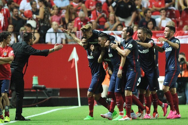 Atletico Madrid's Argentinian coach Diego Simeone (L) celebrates with his team after Atletico Madrid's Colombian forward Jackson Martínez scored a goal during the Spanish league football match Sevilla FC vs Club Atletico de Madrid at the Ramon Sanchez Pizjuan stadium in Sevilla on August 30, 2015.   AFP PHOTO/ CRISTINA QUICLER        (Photo credit should read CRISTINA QUICLER/AFP/Getty Images)