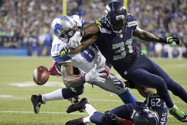 Kam Chancellor, safety de los Seahawks de Dallas, provoca que Calvin Johnson, de los Lions de Detroit, suelte el balón en el encuentro del lunes 5 de octubre de 2015 (AP Foto/Elaine Thompson)