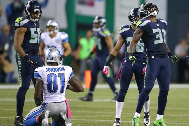 Seattle Seahawks strong safety Kam Chancellor, right, celebrates his tackle of Detroit Lions wide receiver Calvin Johnson in the second half of an NFL football game, Monday, Oct. 5, 2015, in Seattle. The Seahawks beat the Lions 13-10. (AP Photo/Scott Eklund)