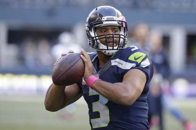 Seattle Seahawks quarterback Russell Wilson, wearing pink for breast cancer awareness, passes during warmups before an NFL football game against the Detroit Lions, Monday, Oct. 5, 2015, in Seattle. (AP Photo/Elaine Thompson)