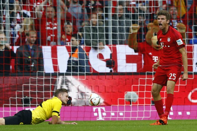 Bayern's Thomas Mueller celebrates besides Dortmund's Lukasz Piszczekafter scoring his opening goal during the Bundesliga soccer match between FC Bayern Munich and Borussia Dortmund at the Allianz Arena stadium in Munich, Germany, Sunday, Oct. 4, 2015. (AP Photo/Matthias Schrader)