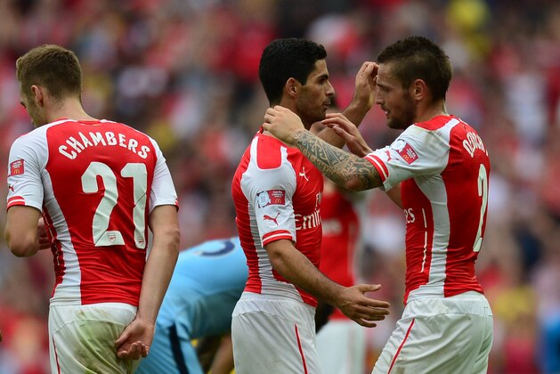 Arsenal's Spanish midfielder Mikel Arteta (C) embraces Arsenal's French defender Mathieu Debuchy (R) at the final whistle after Arsenal won the FA Community Shield football match between Arsenal Manchester City at Wembley Stadium in north London on August 10, 2014. AFP PHOTO / CARL COURT  --  NOT FOR MARKETING OR ADVERTISING USE / RESTRICTED TO EDITORIAL USE        (Photo credit should read CARL COURT/AFP/Getty Images)