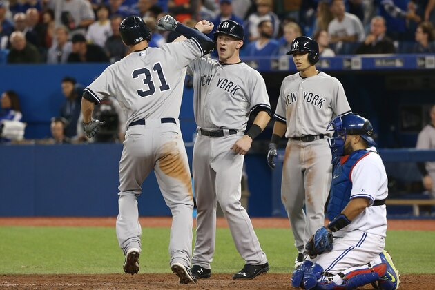 TORONTO, CANADA - SEPTEMBER 22: Greg Bird #31 of the New York Yankees is congratulated by Slade Heathcott #72 after hitting a three-run home run in the 10th inning during MLB game action against the Toronto Blue Jays on September 22, 2015 at Rogers Centre in Toronto, Ontario, Canada. (Photo by Tom Szczerbowski/Getty Images)